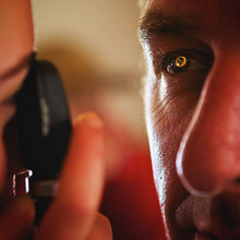 Load image into Gallery viewer, Remote EMT assessing her patients eyes with an ophthalmoscope
