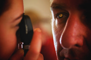 Remote EMT assessing her patients eyes with an ophthalmoscope